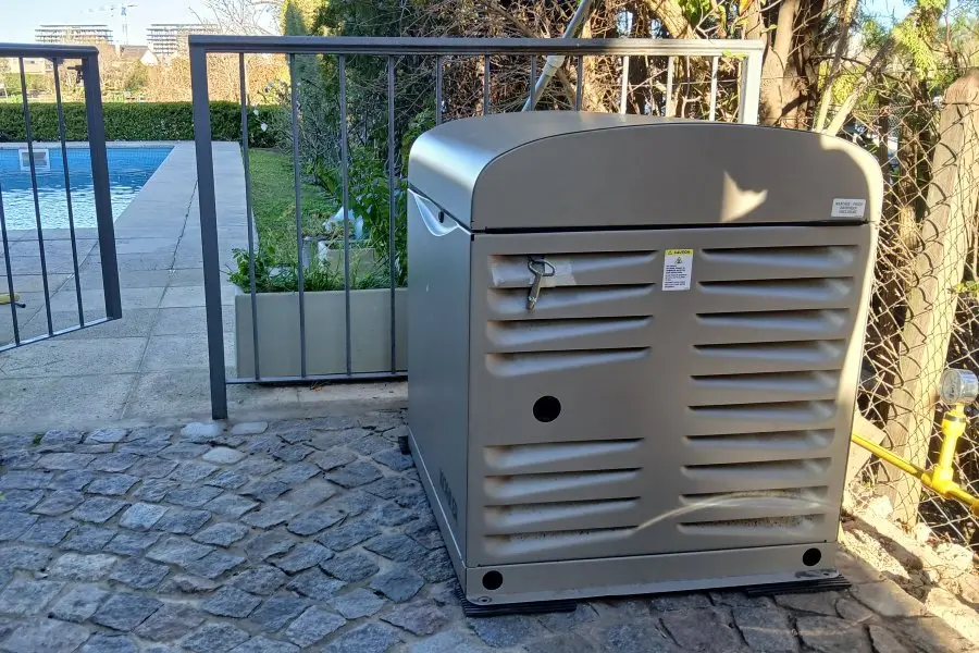 Generador Kohler 9 kVA a gas instalado en vivienda con jardín y piscina